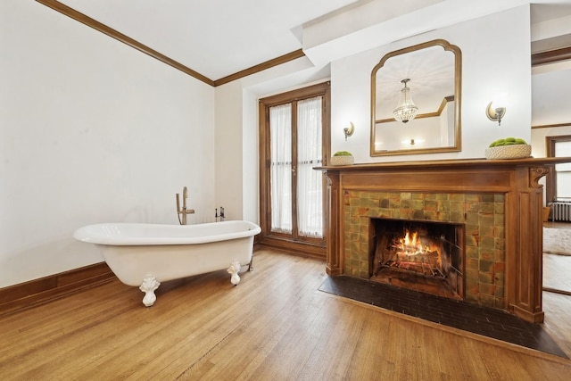 5235 S University Ave, Chicago, IL 60615 - bathroom with wood finished floors, ornamental molding, a soaking tub, baseboards, and a fireplace