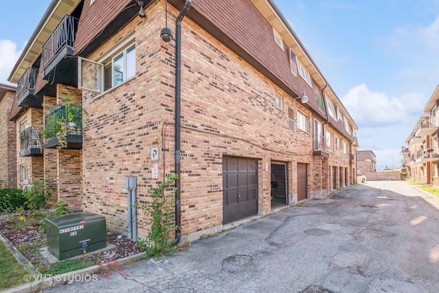 view of side of property featuring a balcony and a garage