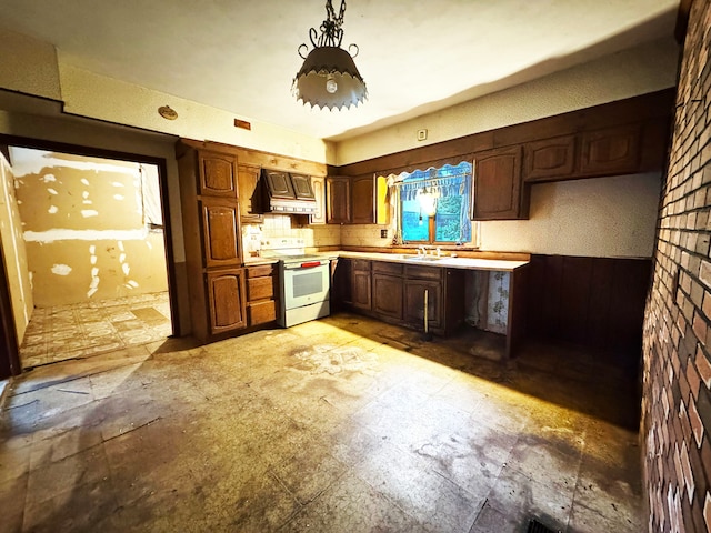 kitchen with sink, custom range hood, wooden walls, decorative light fixtures, and white range with electric stovetop