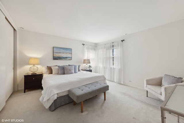 bedroom featuring light carpet and a closet