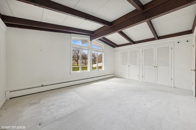 empty room featuring lofted ceiling with beams, light colored carpet, and baseboard heating