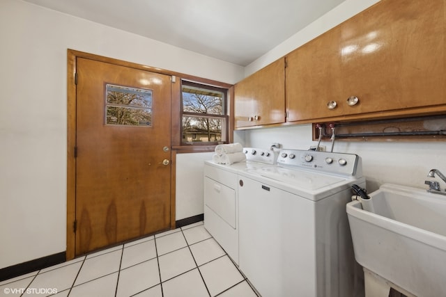 clothes washing area with light tile patterned floors, cabinets, sink, and washer and dryer