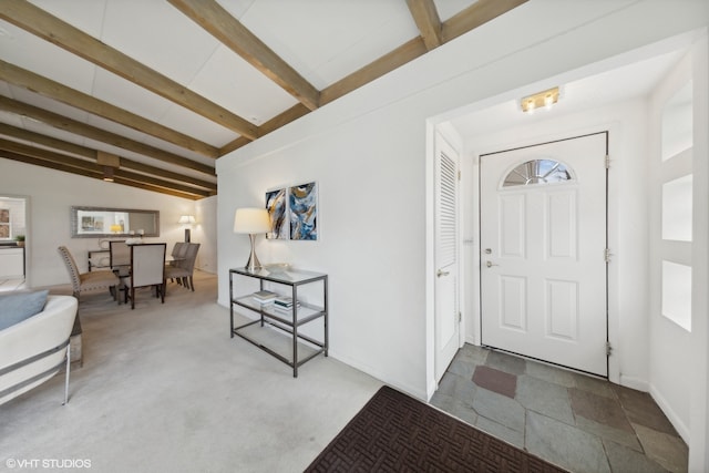 entryway with vaulted ceiling with beams and carpet flooring