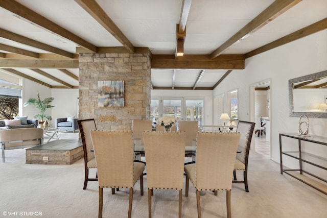 carpeted dining area with a wealth of natural light and vaulted ceiling with beams