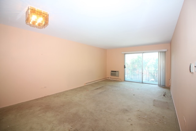 carpeted spare room with a baseboard radiator and an AC wall unit