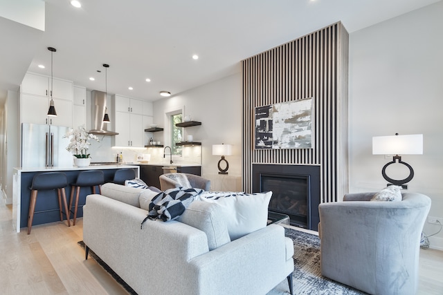 living room with light hardwood / wood-style floors and sink