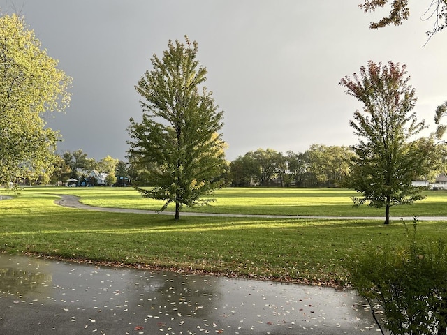 surrounding community featuring a water view and a lawn