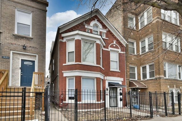 view of front of property with a fenced front yard and brick siding