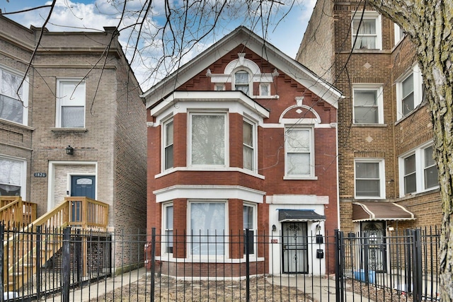 view of front facade with a fenced front yard and brick siding