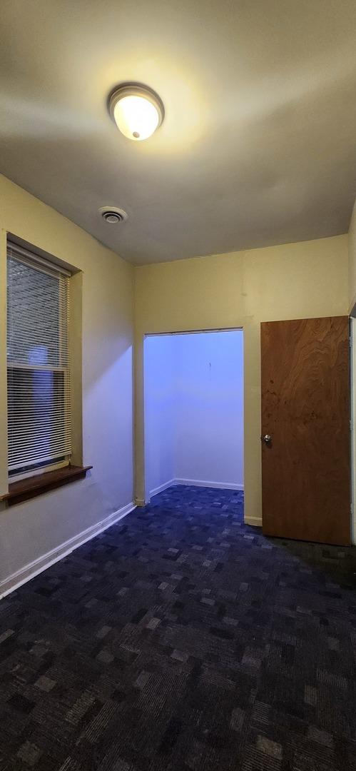 carpeted spare room with visible vents and baseboards