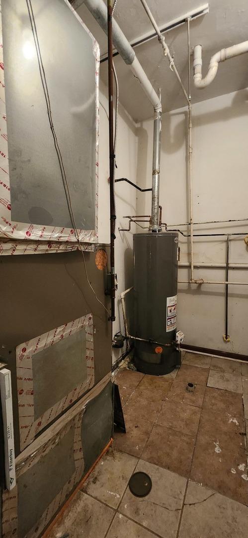 utility room with heating unit and gas water heater