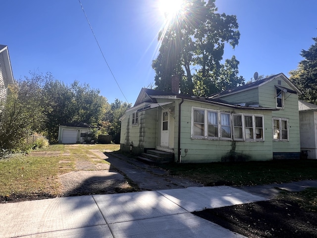 view of front of house with a garage and an outbuilding