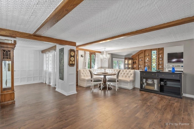 dining room with beam ceiling, dark wood-type flooring, and an inviting chandelier