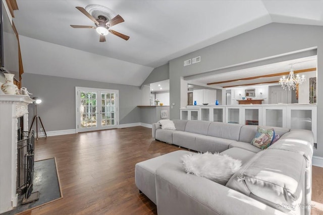 living room featuring a high end fireplace, ceiling fan with notable chandelier, lofted ceiling, and dark wood-type flooring