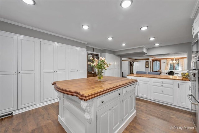 kitchen with wood counters, crown molding, kitchen peninsula, dark hardwood / wood-style floors, and white cabinets