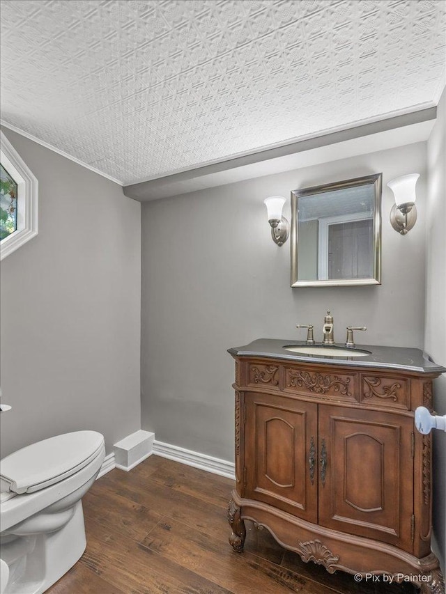 bathroom with toilet, vanity, a textured ceiling, and hardwood / wood-style flooring