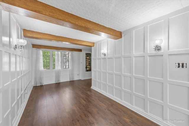 spare room featuring beam ceiling and dark hardwood / wood-style flooring