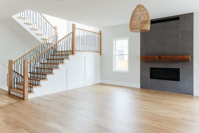 unfurnished living room with hardwood / wood-style floors and a large fireplace