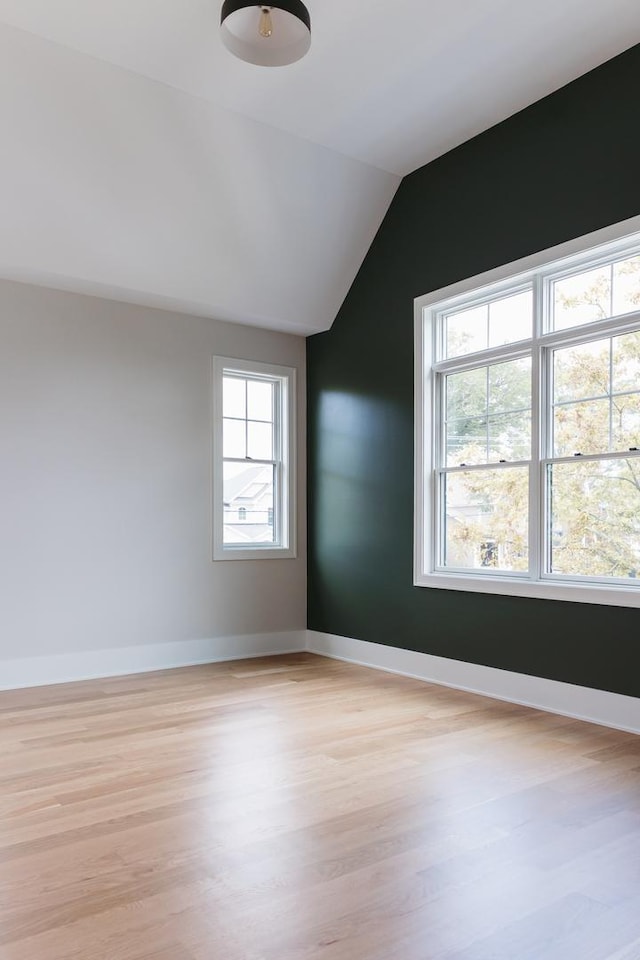 additional living space featuring light hardwood / wood-style floors and lofted ceiling