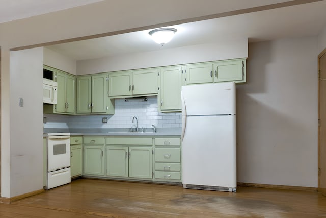 kitchen with green cabinets, light hardwood / wood-style flooring, sink, and white appliances