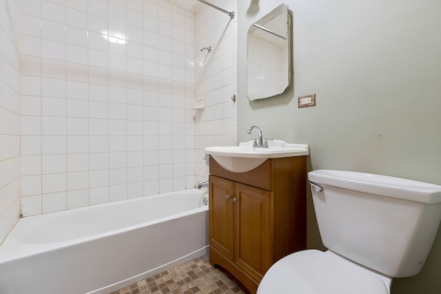 full bathroom featuring tiled shower / bath, vanity, and toilet