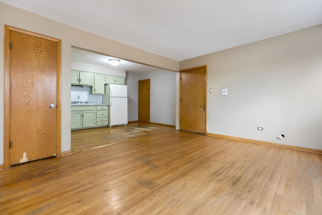 unfurnished living room featuring light hardwood / wood-style flooring and sink