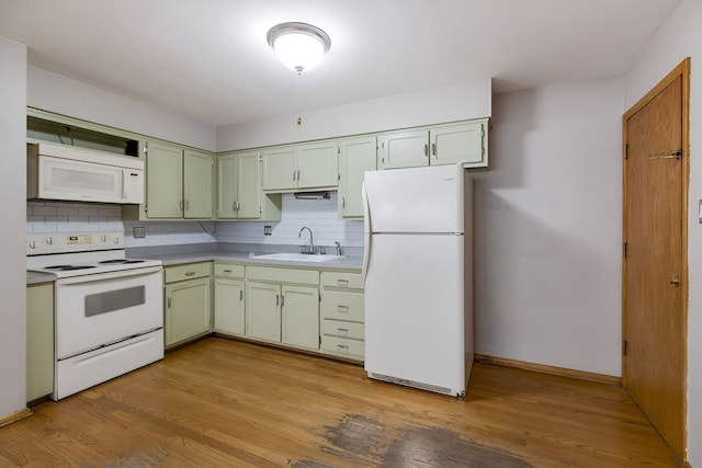 kitchen with decorative backsplash, white appliances, light hardwood / wood-style floors, and sink