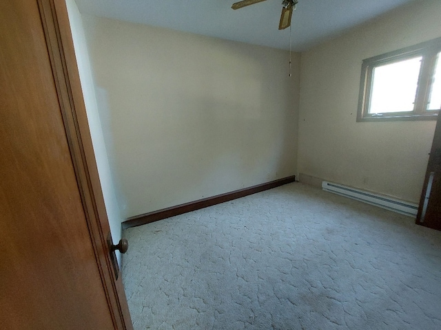 carpeted empty room featuring ceiling fan and baseboard heating