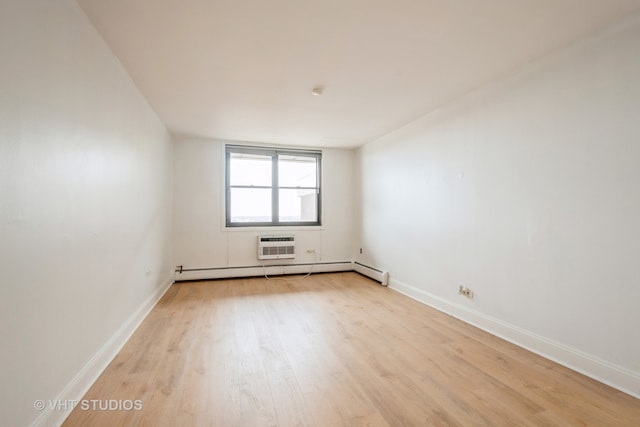 unfurnished room featuring a baseboard radiator, light hardwood / wood-style flooring, and a wall unit AC