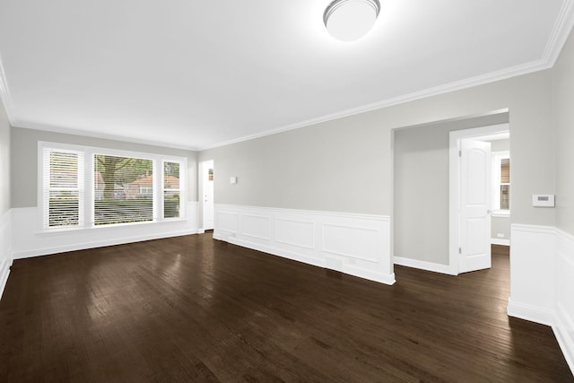 empty room with ornamental molding and dark hardwood / wood-style flooring