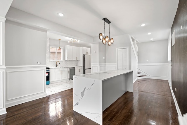 kitchen with fridge, dark hardwood / wood-style floors, wine cooler, and white cabinets