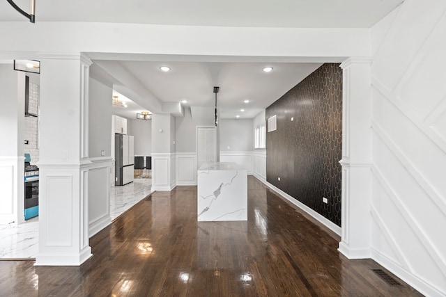 interior space with dark hardwood / wood-style floors and ornate columns