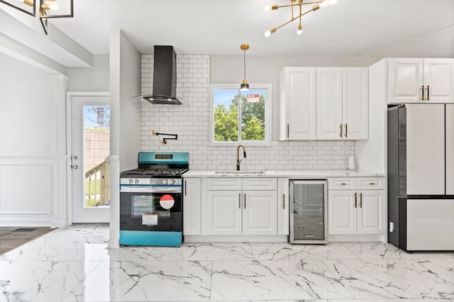 kitchen featuring wine cooler, stainless steel range with gas cooktop, wall chimney exhaust hood, fridge, and an inviting chandelier