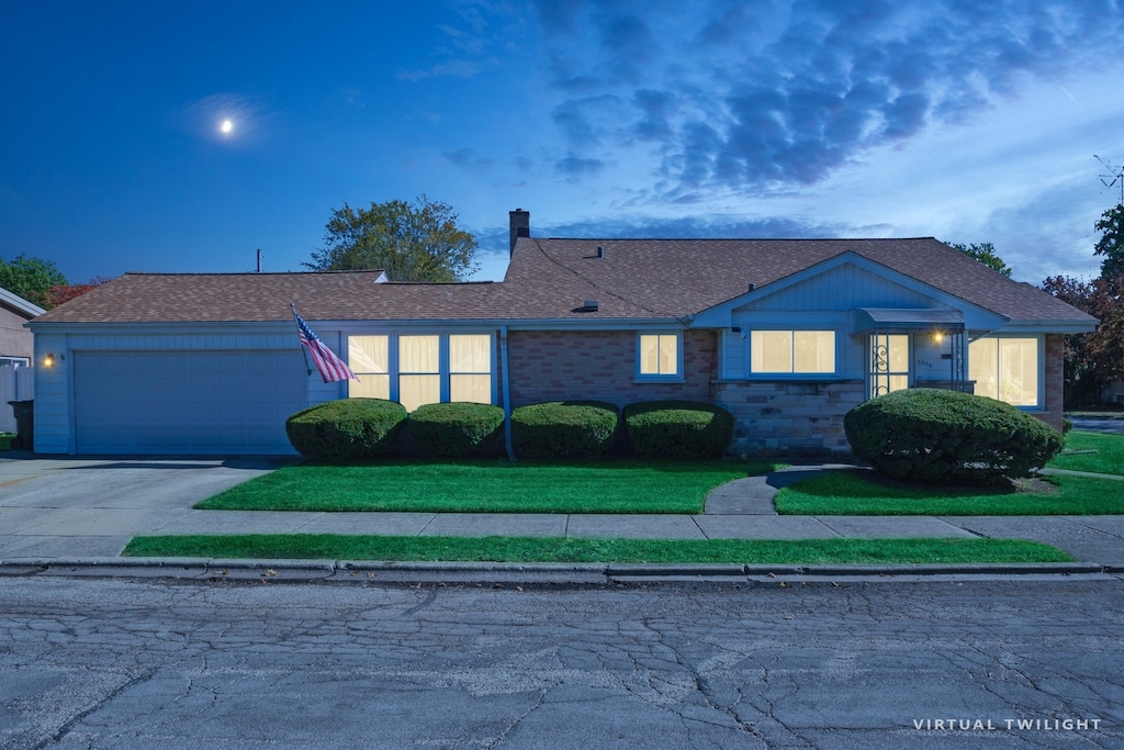 ranch-style home featuring a garage and a lawn