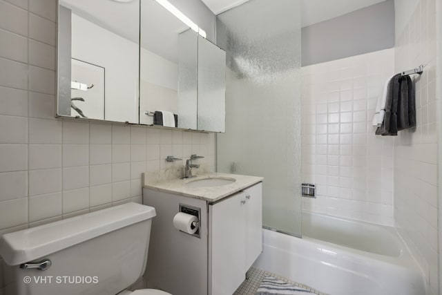 full bathroom with toilet, tile walls, decorative backsplash, tiled shower / bath combo, and vanity