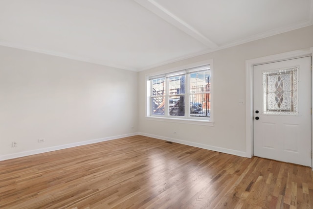 foyer with ornamental molding, beam ceiling, and light hardwood / wood-style floors