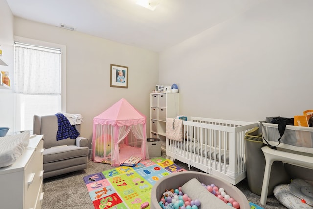 bedroom featuring light carpet and a nursery area