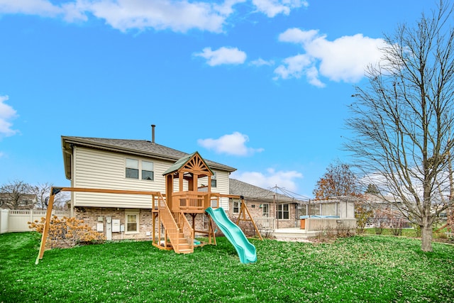 back of property featuring a playground and a yard