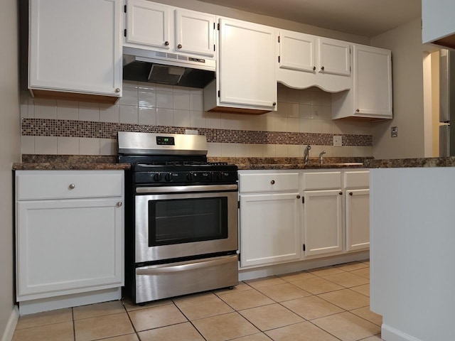 kitchen with decorative backsplash, stainless steel gas range oven, sink, white cabinetry, and light tile patterned flooring