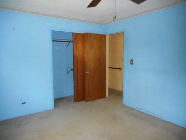 unfurnished bedroom with a closet, ceiling fan, and light colored carpet