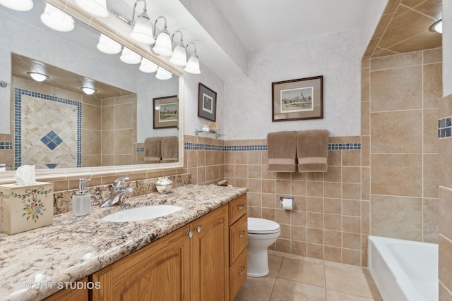 full bathroom with vanity, tile walls, toilet, and tile patterned floors