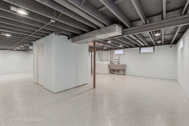 basement with sink and washing machine and dryer