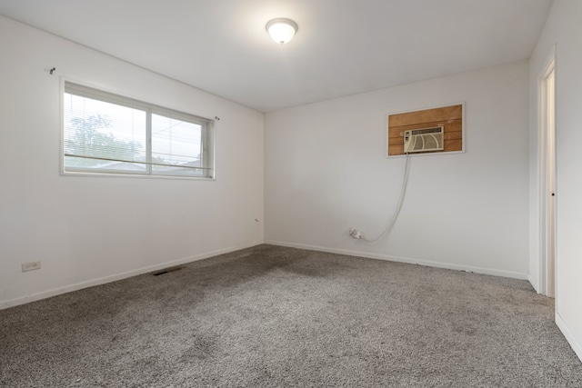 carpeted spare room featuring an AC wall unit