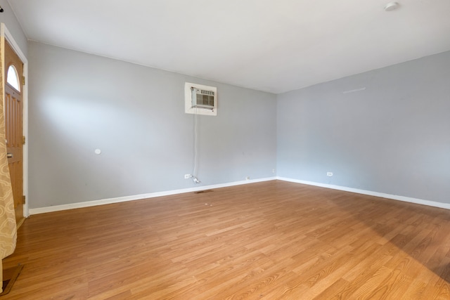 unfurnished room with light hardwood / wood-style floors and a wall mounted air conditioner