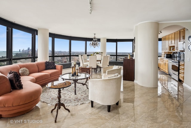 living room with a notable chandelier, floor to ceiling windows, and a wealth of natural light