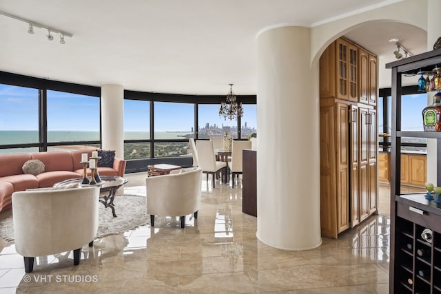 living room featuring a wall of windows, a chandelier, and a water view