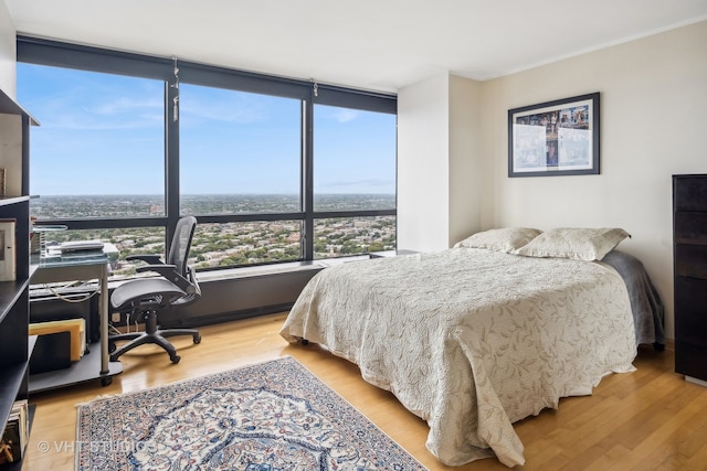 bedroom with light hardwood / wood-style flooring and expansive windows