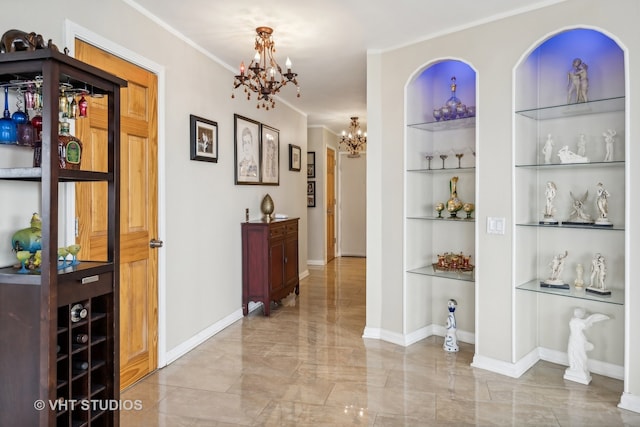 hallway with crown molding, built in shelves, and an inviting chandelier