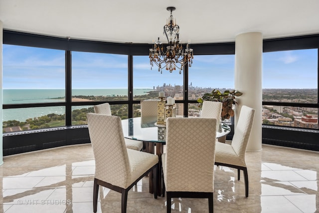 dining area with an inviting chandelier, a water view, and a healthy amount of sunlight