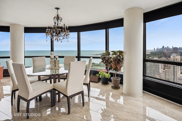 tiled dining room featuring an inviting chandelier, floor to ceiling windows, and a water view